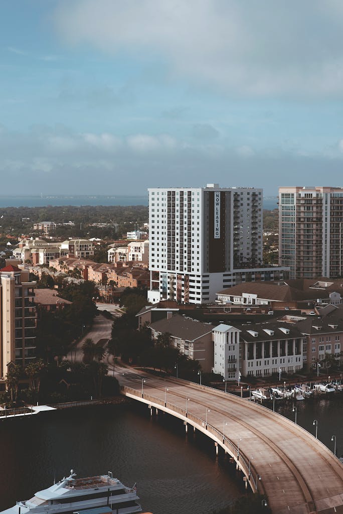 A high-angle view of a modern city skyline with a bridge over the waterfront.