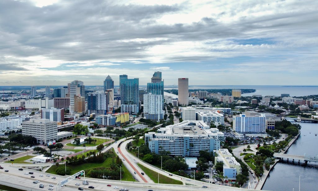 A stunning aerial view of Tampa, FL cityscape featuring modern skyscrapers against clouded skies.